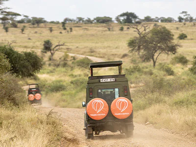 TourCompass safari vehicle driving on a road in Tanzania