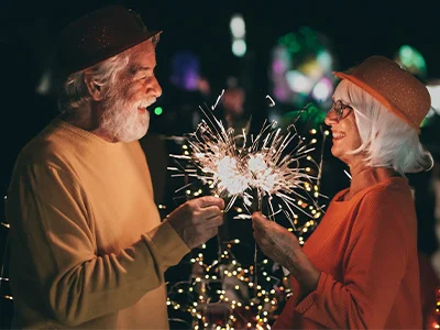 Older couple celebrate New Year with sparklers