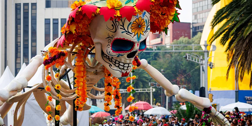 A large skeleton decorated with flowers for a parade on the Day of the Dead in Mexico City