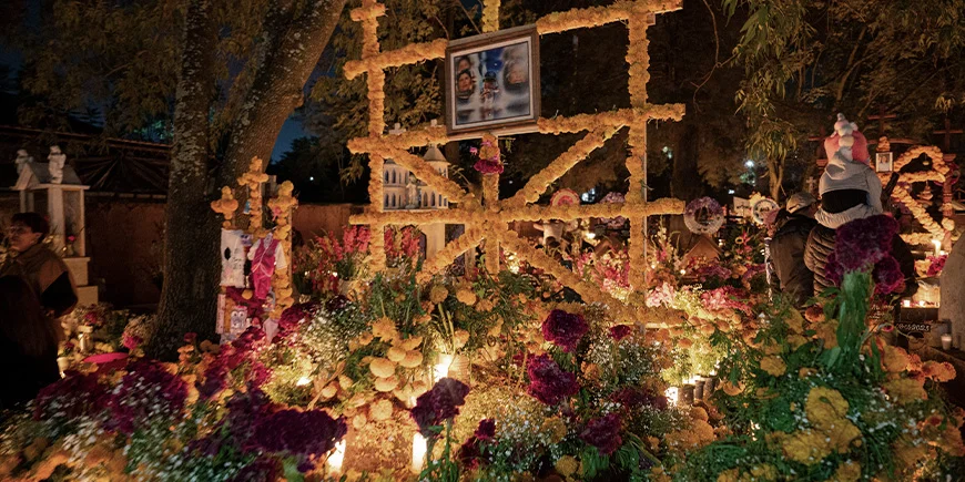 A grave decorated with candles, photographs and other decorations for the Day of the Dead in Mexico