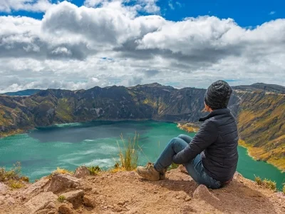 A woman sits on the rim of the Quilotoa crater lake in Ecuador.