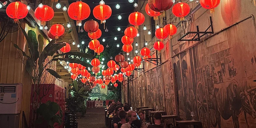 Red lanterns and people dining at Kwai Chai Hong in Chinatown, Kuala Lumpur