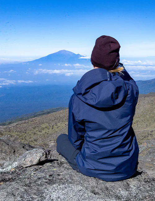 Woman sitting on a mountaintop admiring the view