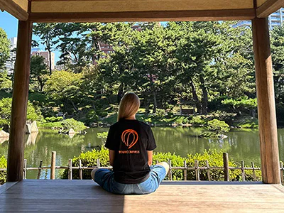 Woman in a TourCompass T-shirt in a beautiful Japanese garden in Hiroshima
