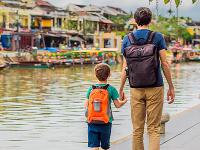 Father and son walk hand in hand in Hoi An
