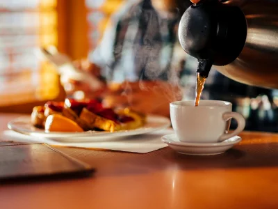 Man sitting in a diner enjoying waffles and a cup of coffee