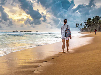 Woman walking along the beach in Sri Lanka