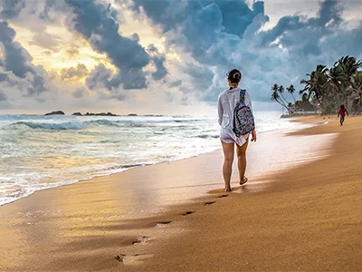 Woman walking along the beach in Sri Lanka