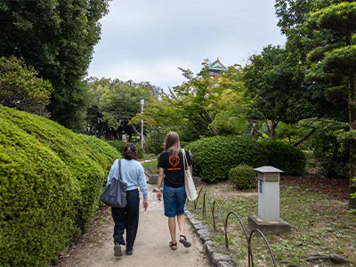 Japanese guide walking with a TourCompass staff member by Osaka Castle in Japan