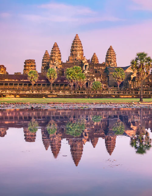 Angkor Wat temple reflecting in water at sunrise