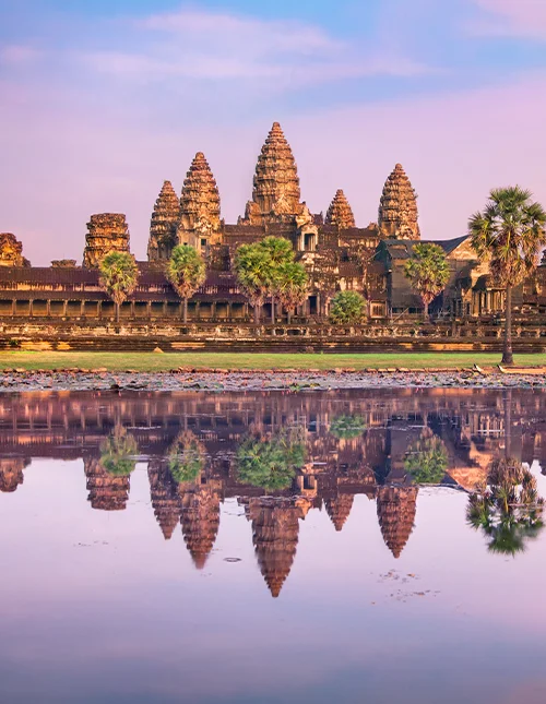 Angkor Wat temple reflecting in water at sunrise