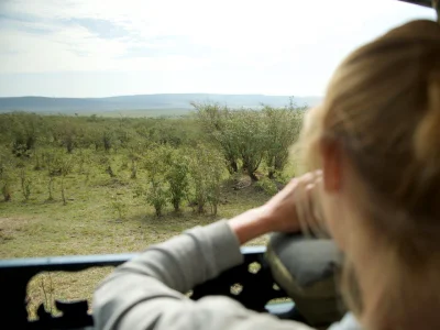 Woman taking a photo of a cheetah in the Masai Mara