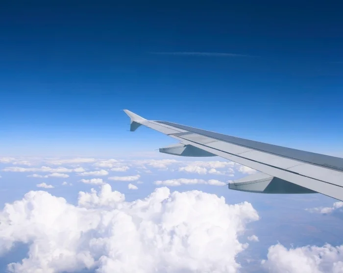 Aircraft wing above the clouds on the way to the destination
