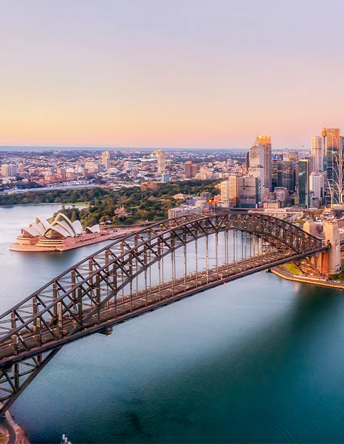 Aerial view over Sydney Harbour Bridge in a purple light.