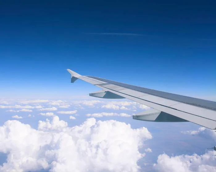 Aeroplane wing above the clouds on the way to the destination