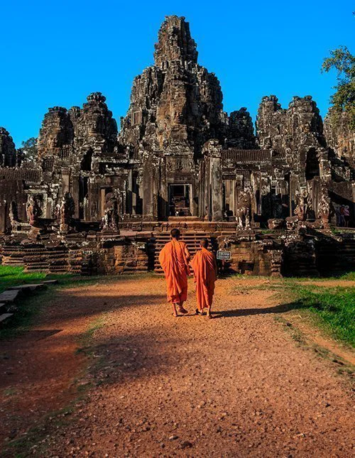 The monks in the ancient stone faces of Bayon temple, Angkor, Cambodia